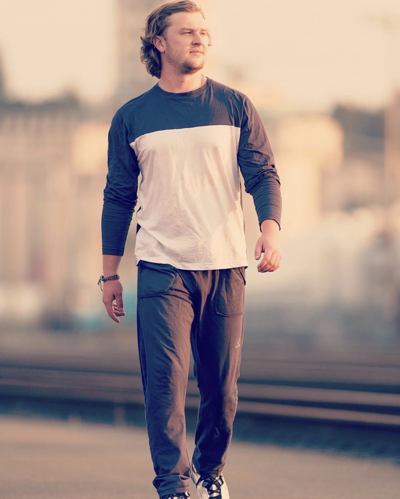 Luc Carlin (LMC) outdoors in warm sunlight wearing a blue-and-white shirt