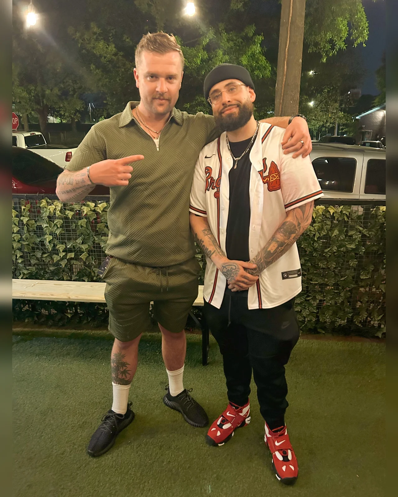 Luc Carlin (LMC) — standing beside a guest outdoors at night wearing a green shirt