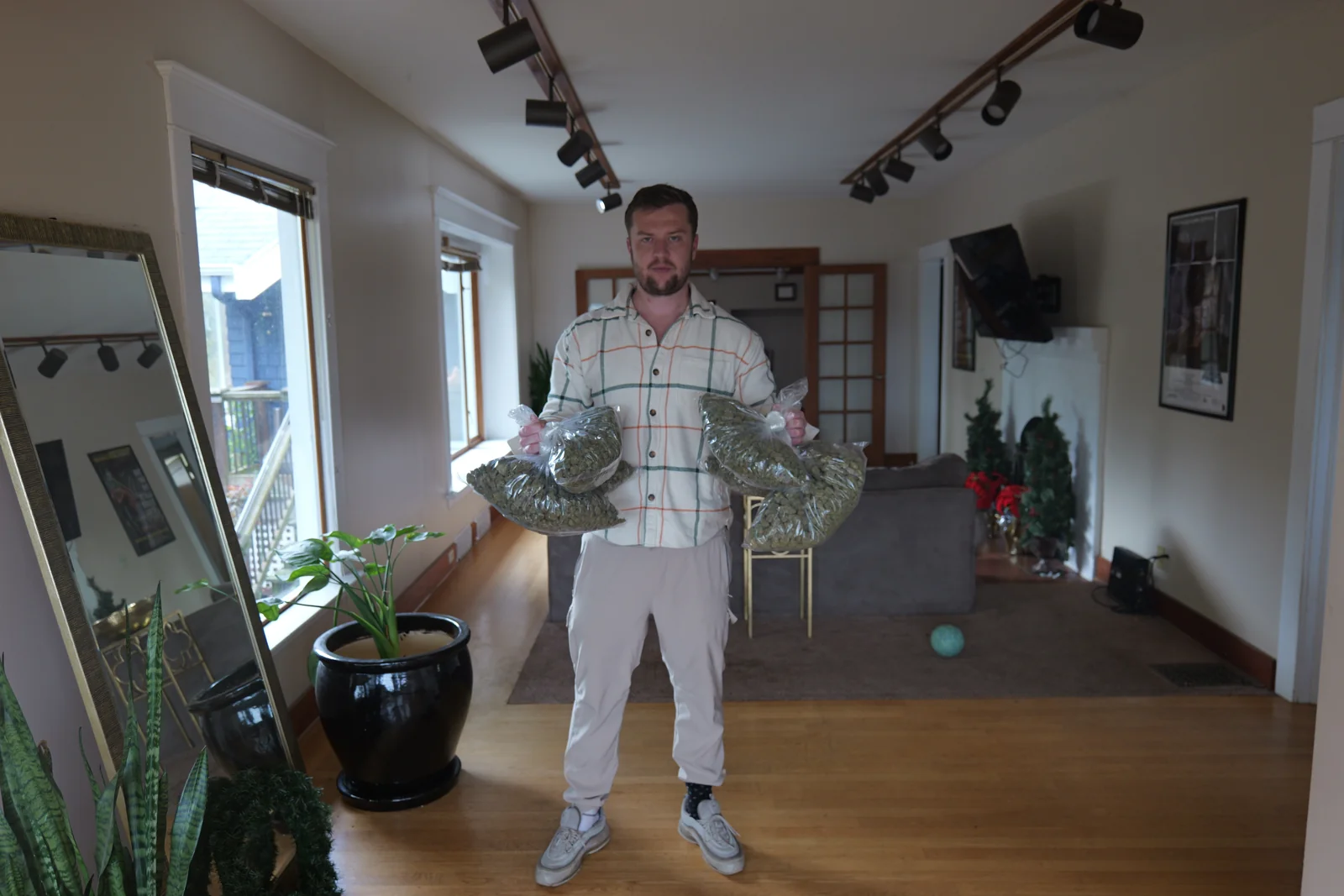Luc Carlin (LMC) — standing beside a window wearing a patterned shirt and light trousers